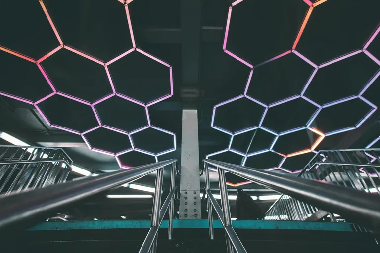 An underground space illuminated by modern, hexagonal LED light fixtures, creating a vibrant and contemporary atmosphere.